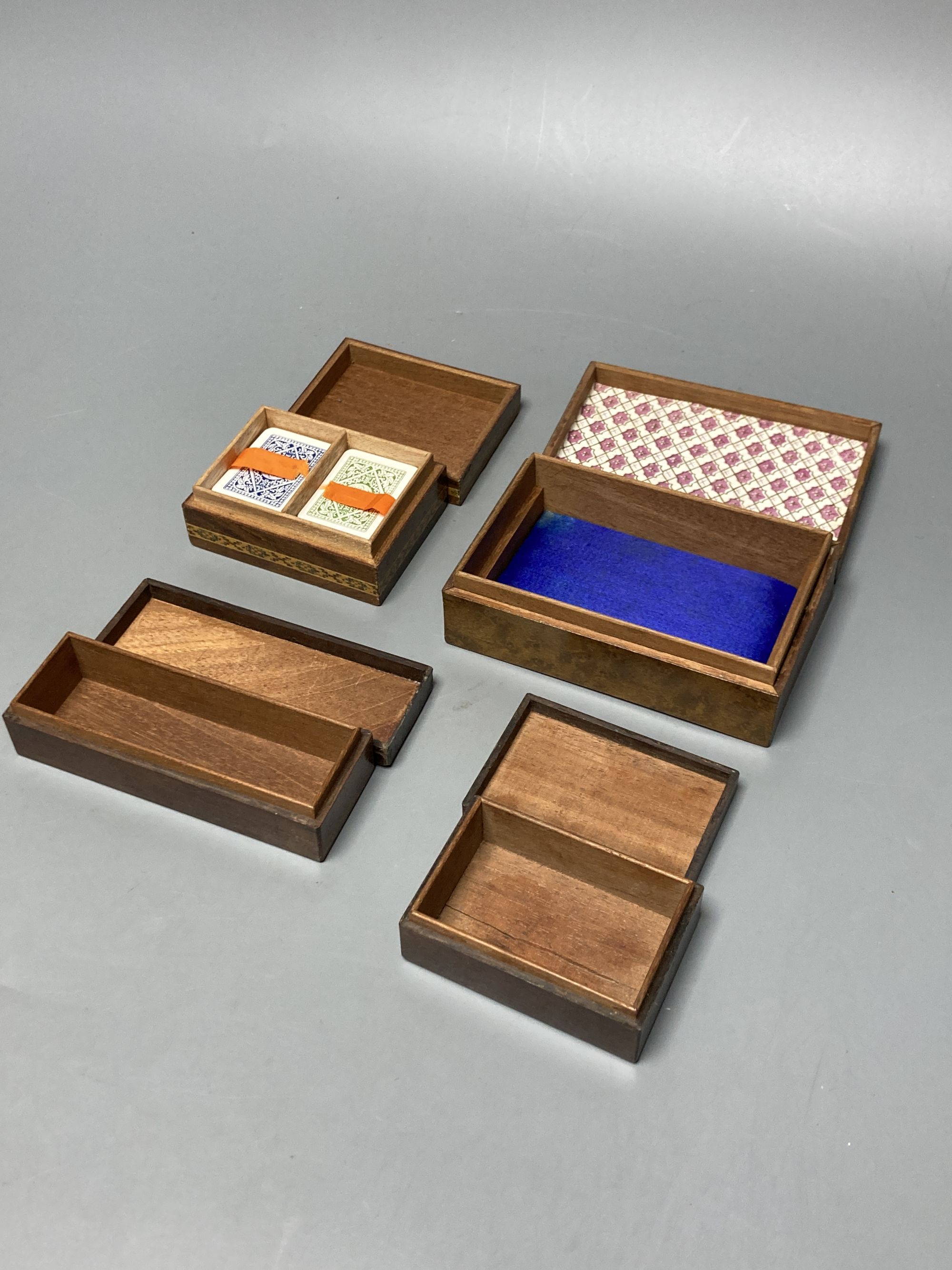 Four Tunbridge ware perspective cube marquetry small boxes, early 20th century, largest 12.2cm, one containing Goodall, London miniature playings cards (not checked if complete), 8.2cm and another with Thomas Barton inks